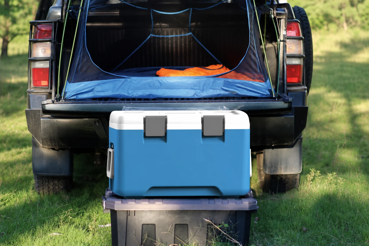 Insulated cooler beside an outdoor vehicle and shelter